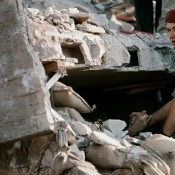 Yan Morvan "Un soldat franais tient la main dun survivant dans les ruines de limmeuble  Drakkar , Beyrouth-Ouest" 23 octobre 1983  Paris, muse de l'Arme, Dist. RMN - Grand Palais / Emilie Cambrier / ADAGP, Paris 2021